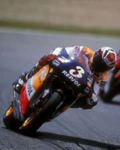 Vintage motorcycle racing poster of 1990s rider leaning into apex