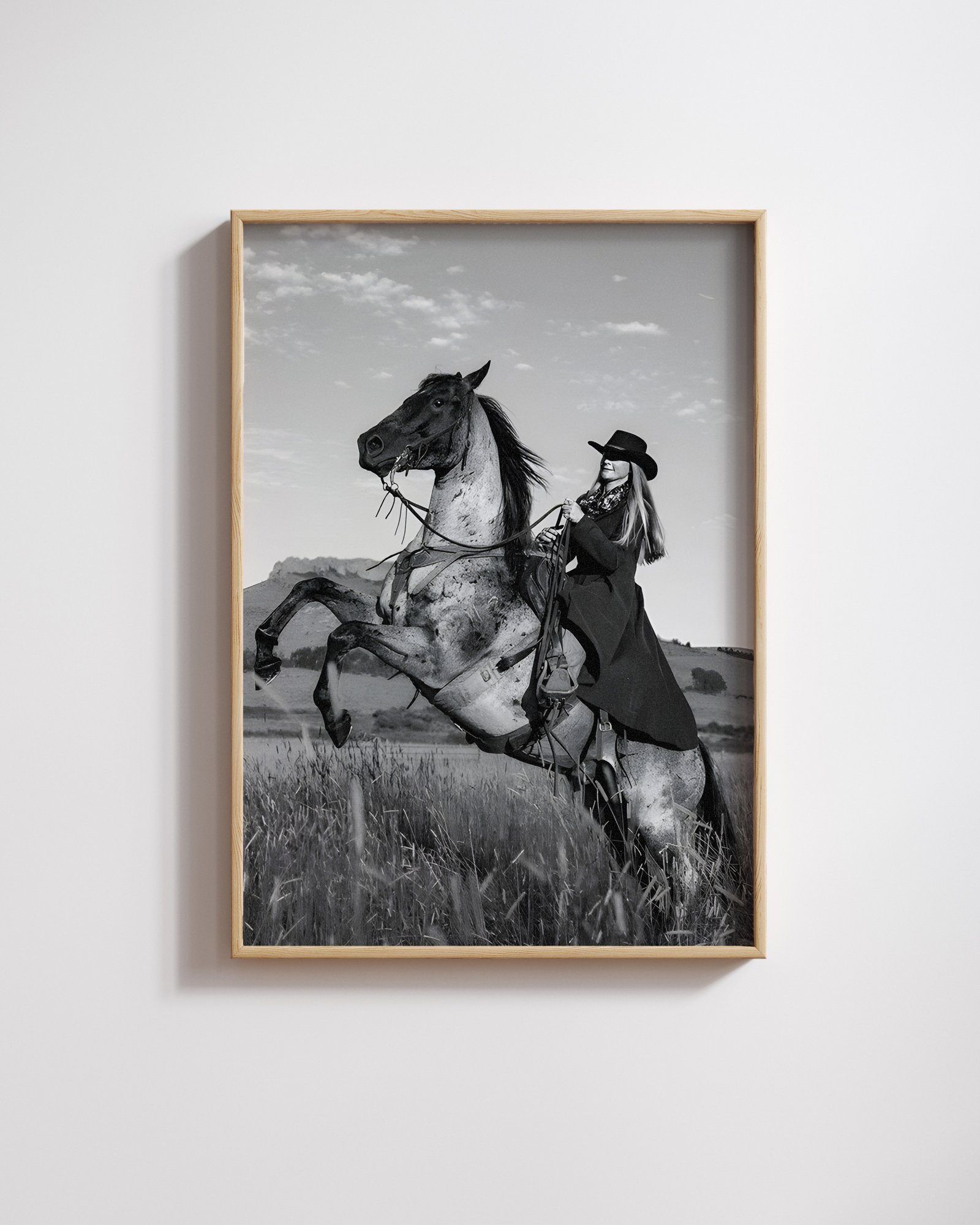 Black and white portrait of a cowgirl riding a horse