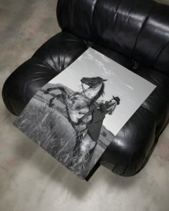 Black and white portrait of a cowgirl riding a horse