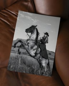 Black and white portrait of a cowgirl riding a horse