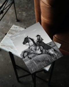 Black and white portrait of a cowgirl riding a horse