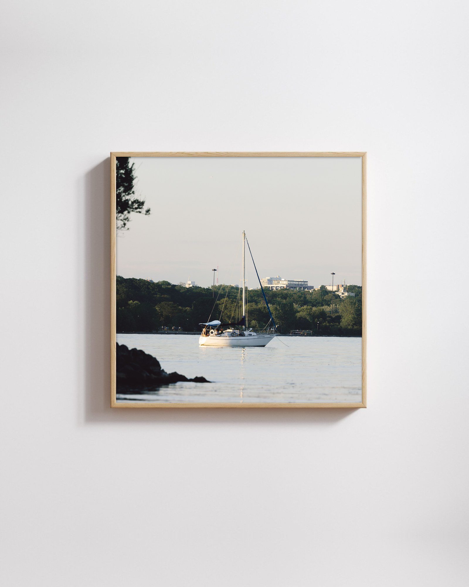 At Anchor by Shazard R., shown framed in natural oak on a white wall