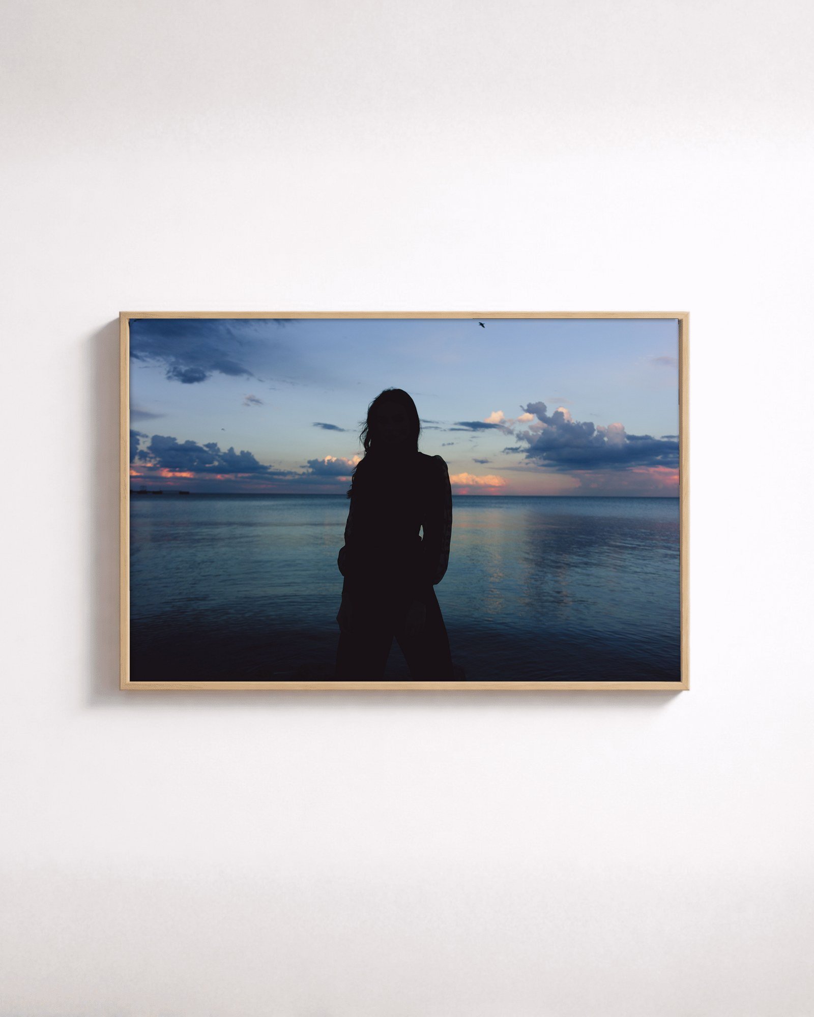 Blue Hour by Shazard R., shown framed in natural oak on a white wall