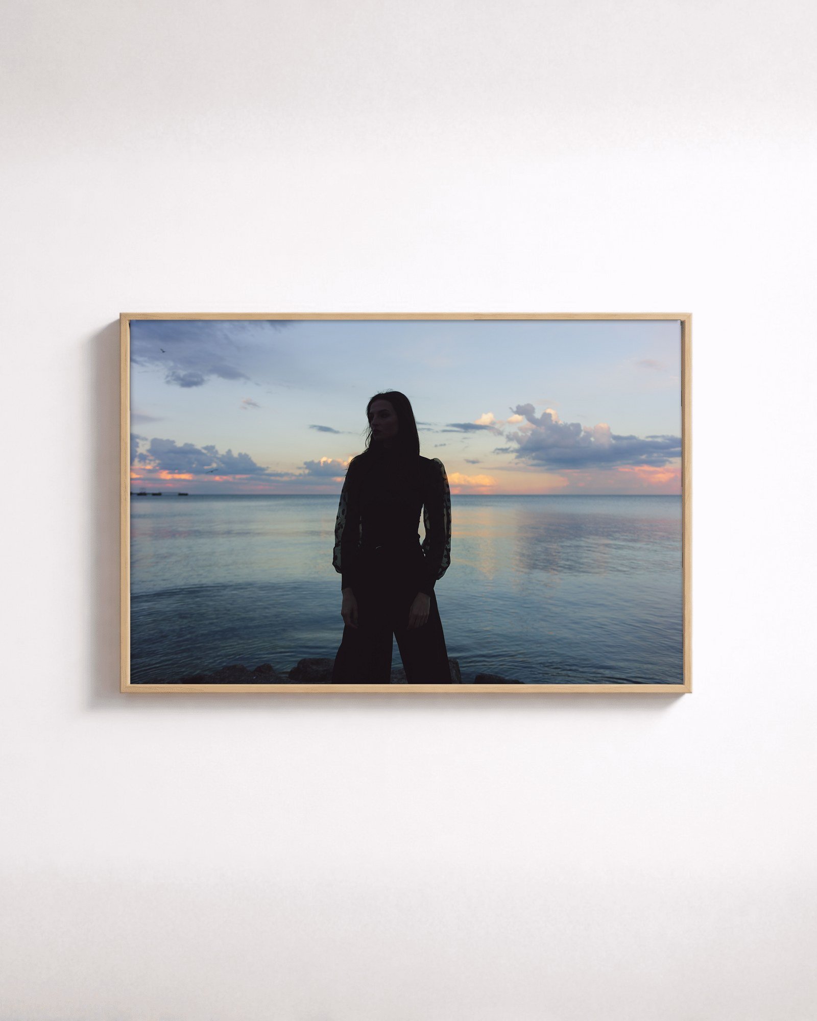 Dusk Figure by Shazard R., shown framed in natural oak on a white wall