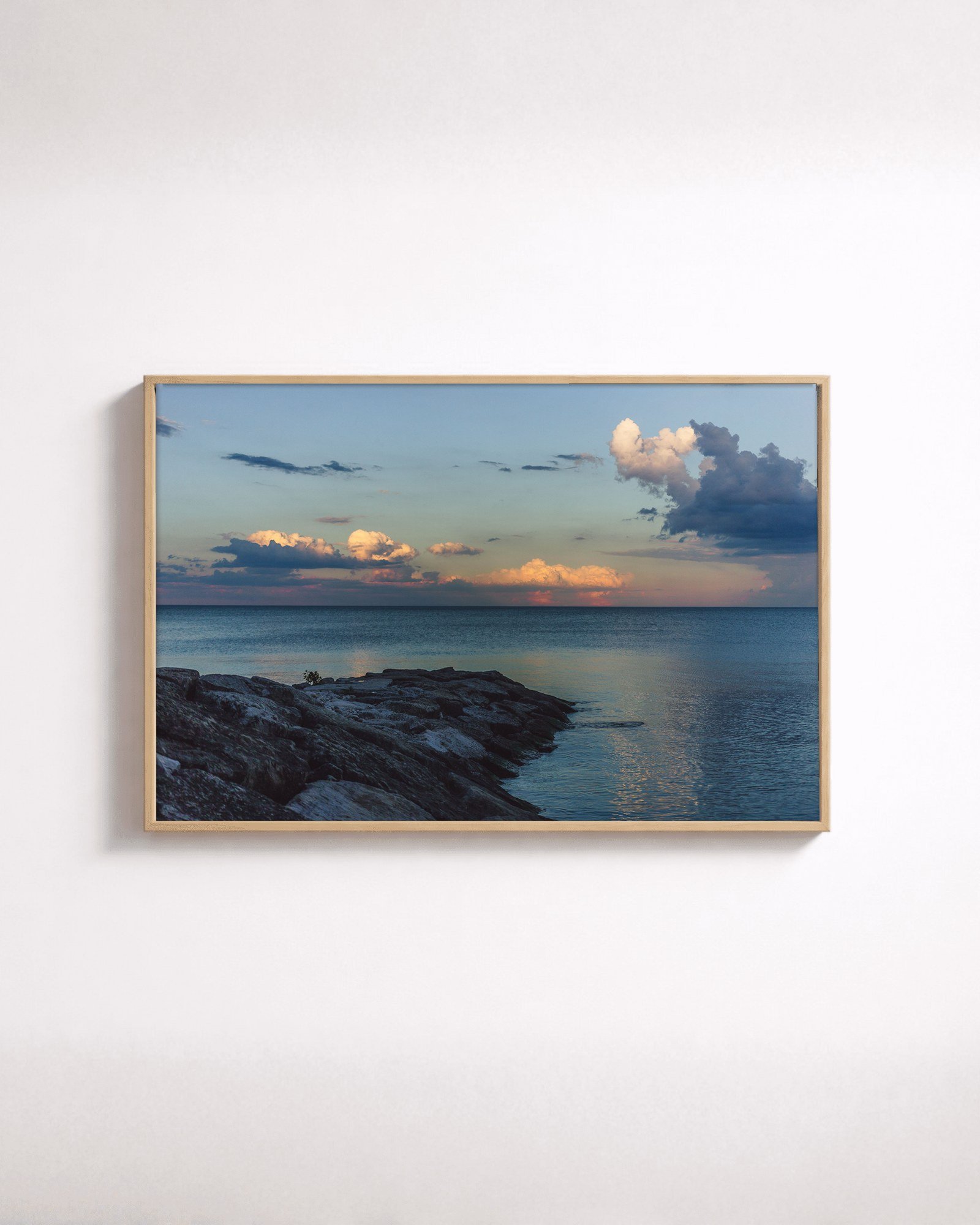 Still Evening by Shazard R., shown framed in natural oak on a white wall
