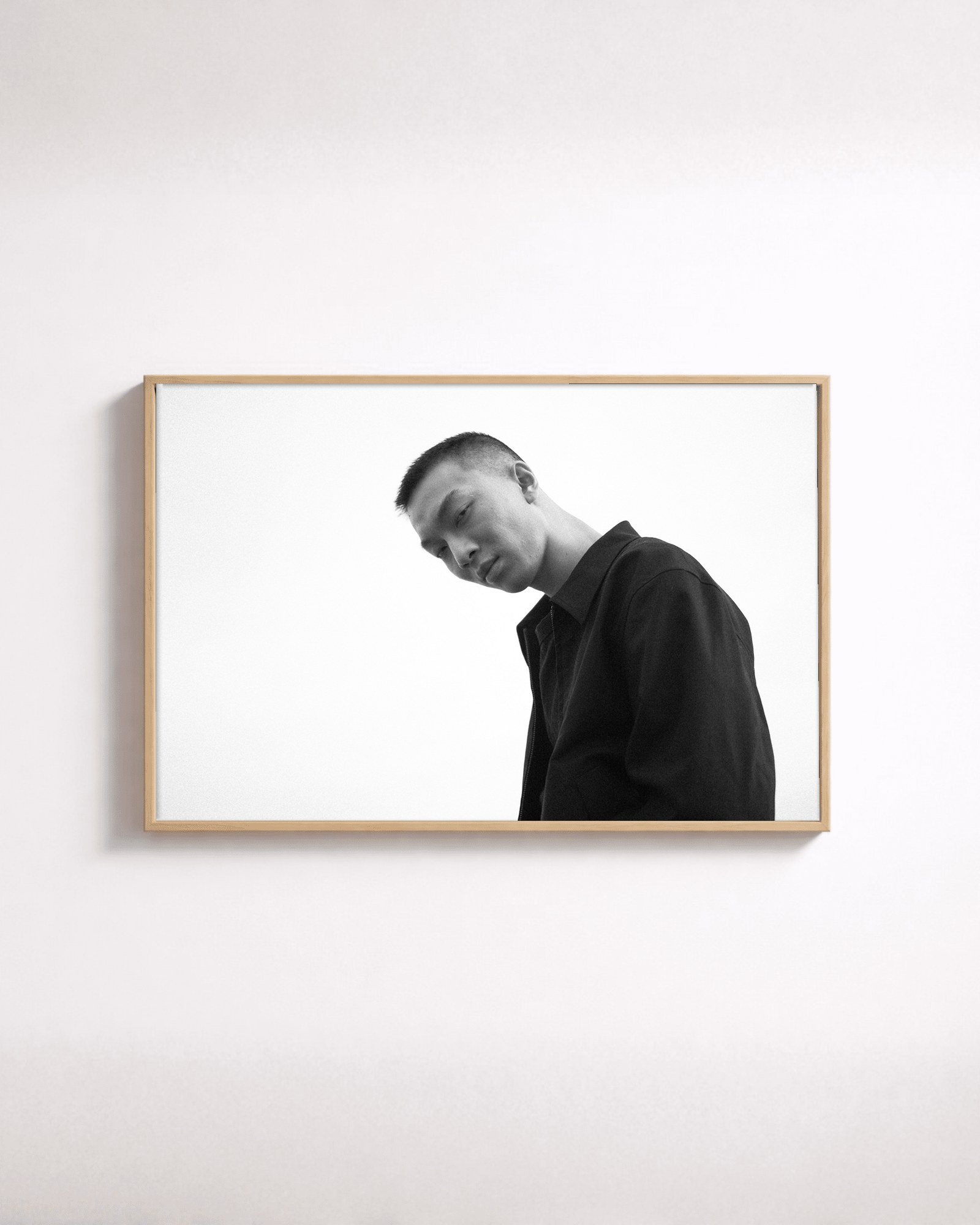 Tilt by Shazard R., shown framed in natural oak on a white wall