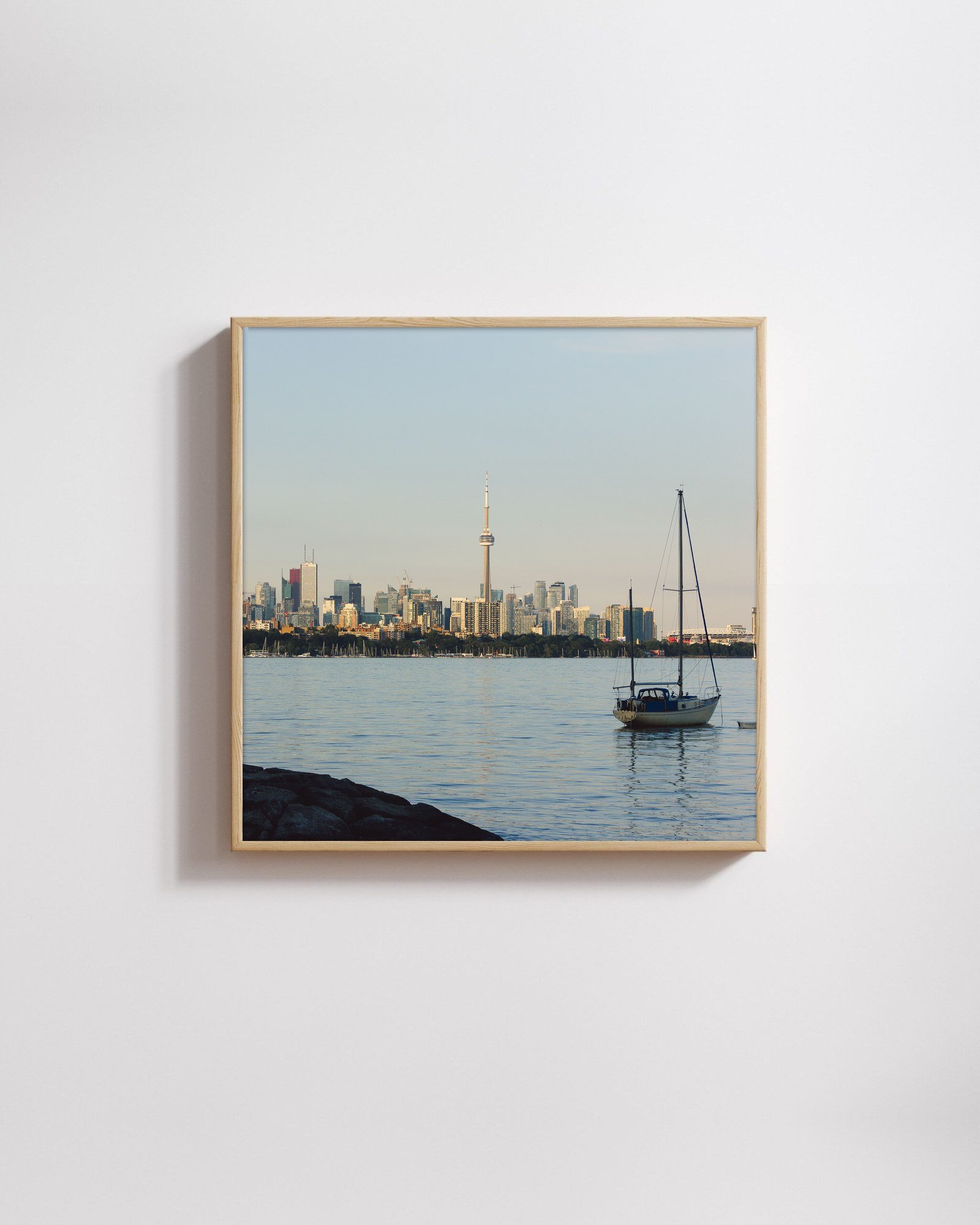 Toronto from the Water by Shazard R., shown framed in natural oak on a white wall